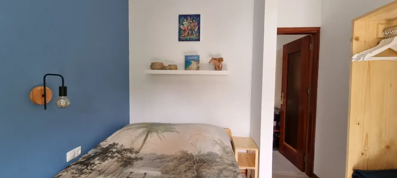 Double bed with botanical bedding and blue accent wall in the Blue Room