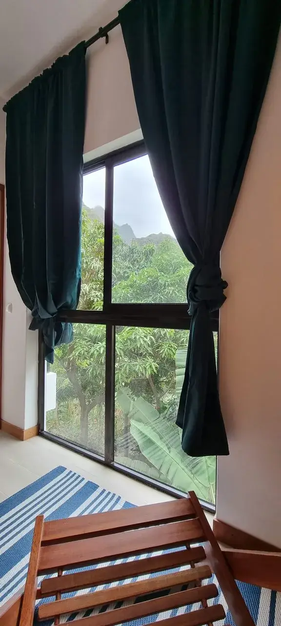 Large Blue Room window overlooking tropical greenery and the mountains