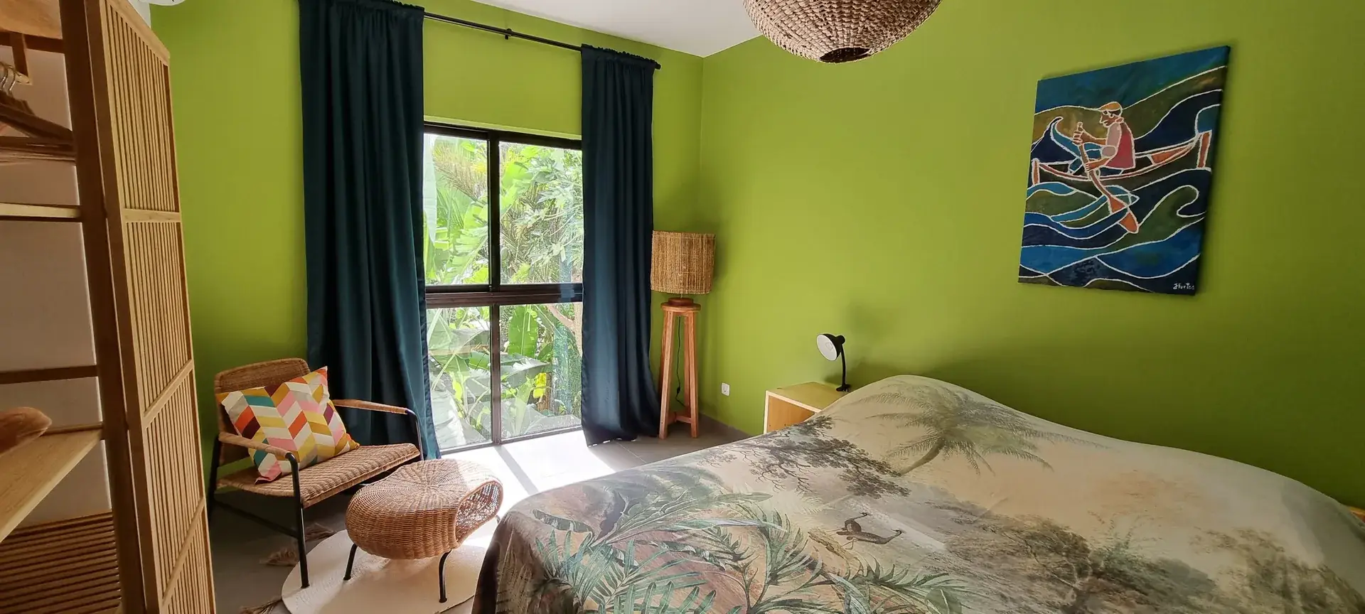 Double bed in the Green Room with green walls, local artwork and garden views