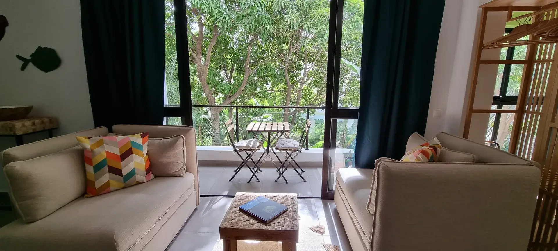 Green Room seating area opening onto a private balcony surrounded by tropical greenery