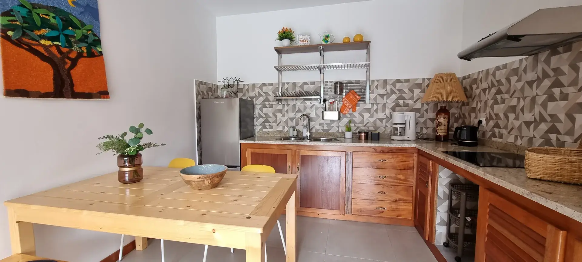Well-equipped Orange Room kitchen with dining table, oven, stovetop and fridge